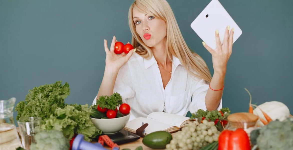 Vlogger promoting healthy eating with fresh vegetables on the table.