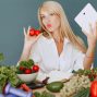 Vlogger promoting healthy eating with fresh vegetables on the table.